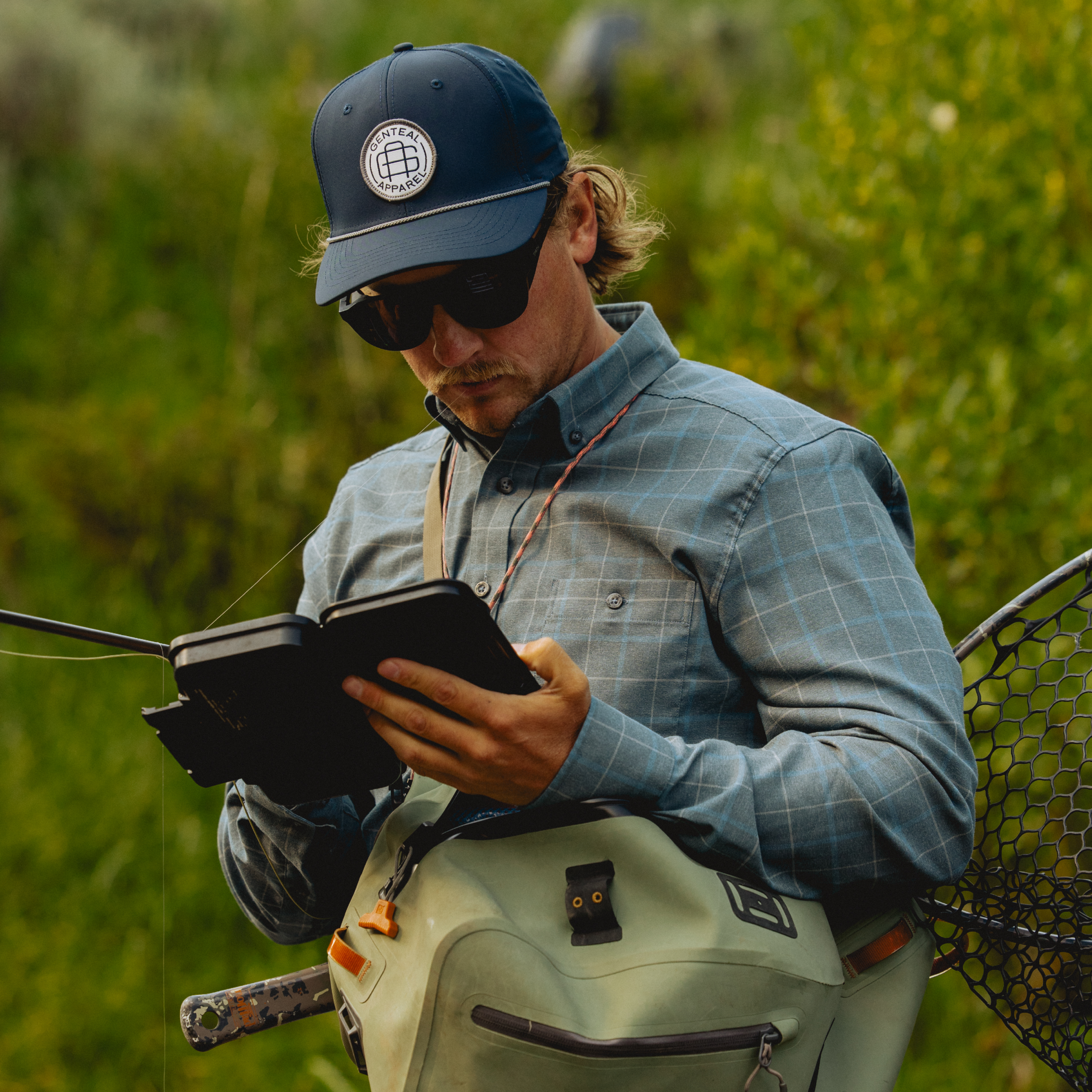 Man getting ready to fly fish in GenTeal clothing and accessories.